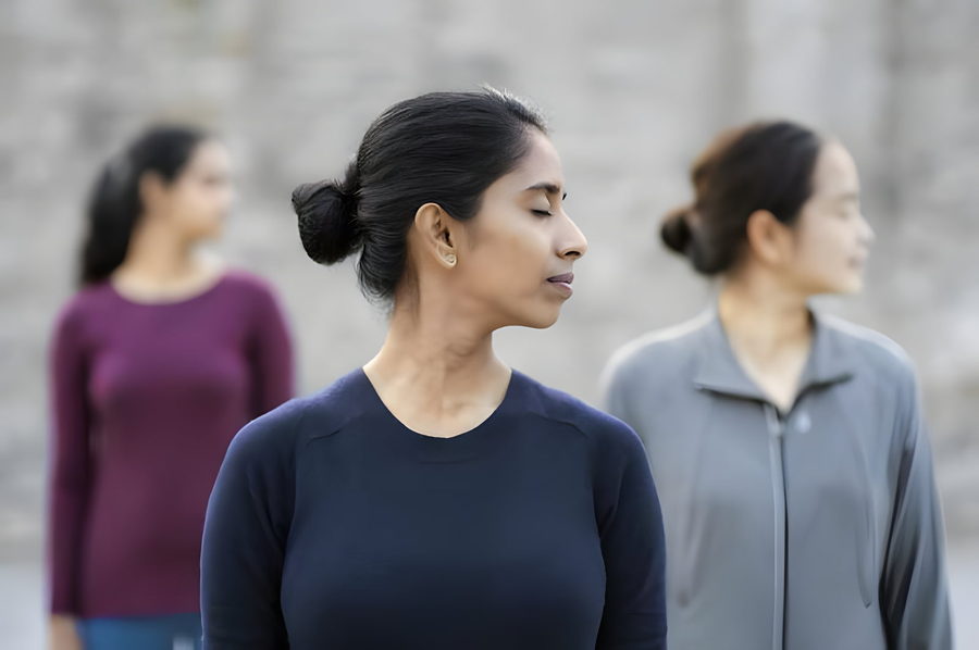 Three women standing in quiet awareness outdoors