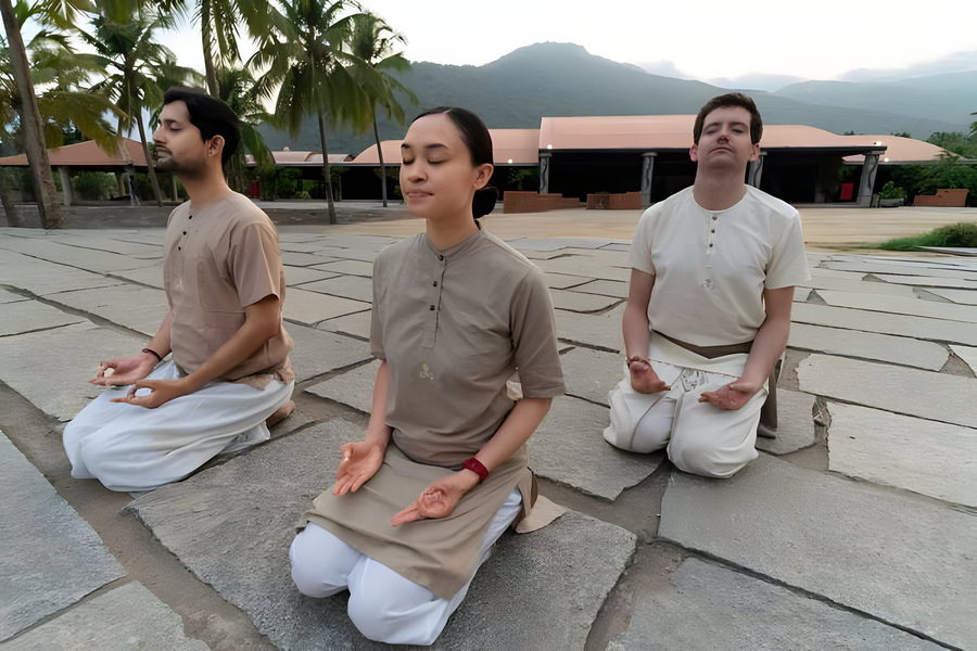 Three practitioners seated in meditation outdoors