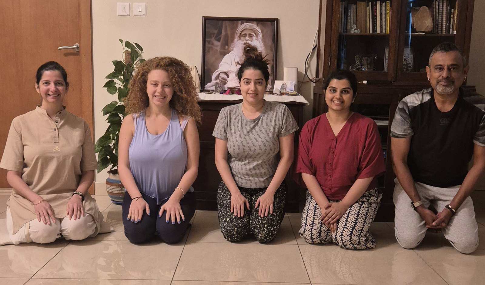 Five adult students kneeling on the studio floor beside Persis after a session